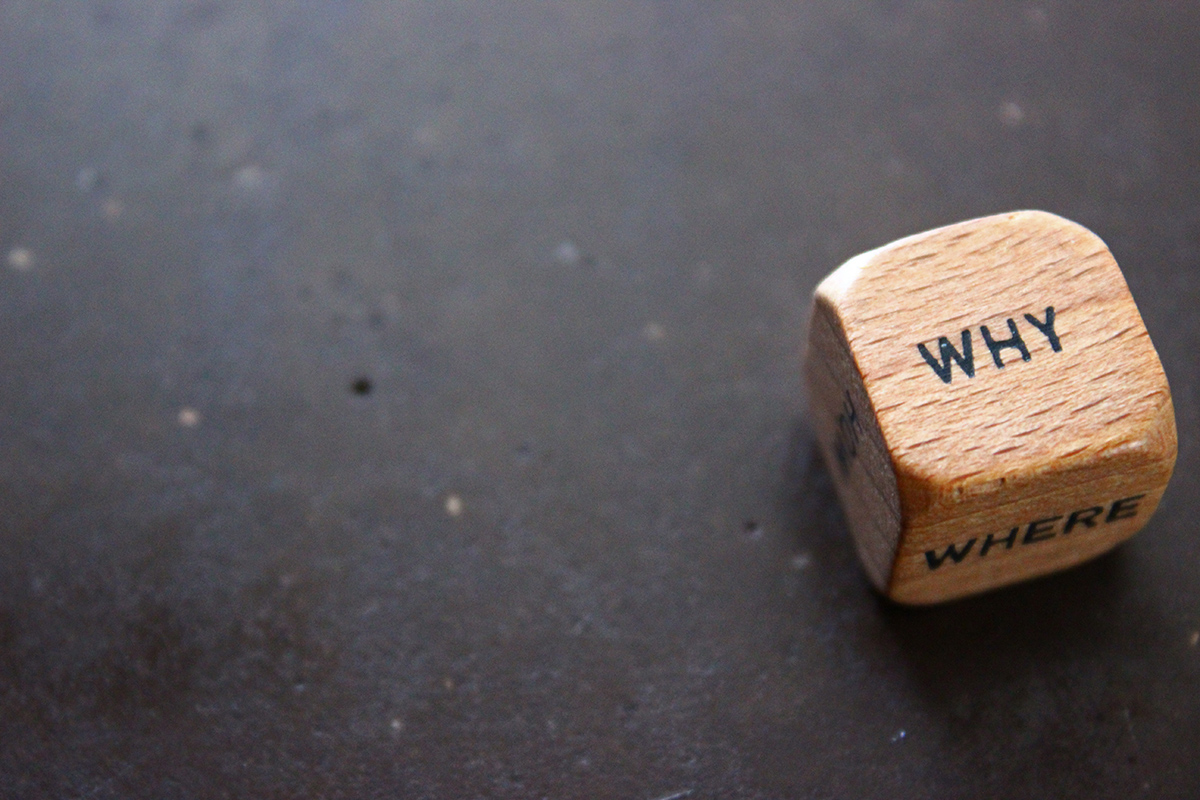 Wooden dice with the word Why on top of it